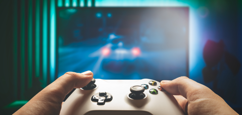 Hands gripping a game controller, a repetitive thumb movement that can strain the tendons at the base of the thumb.