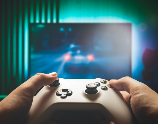 Hands gripping a game controller, a repetitive thumb movement that can strain the tendons at the base of the thumb.